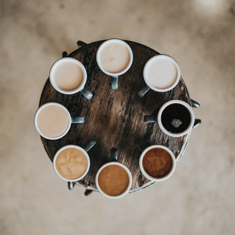 A table full of different coffee drinks, seen from above